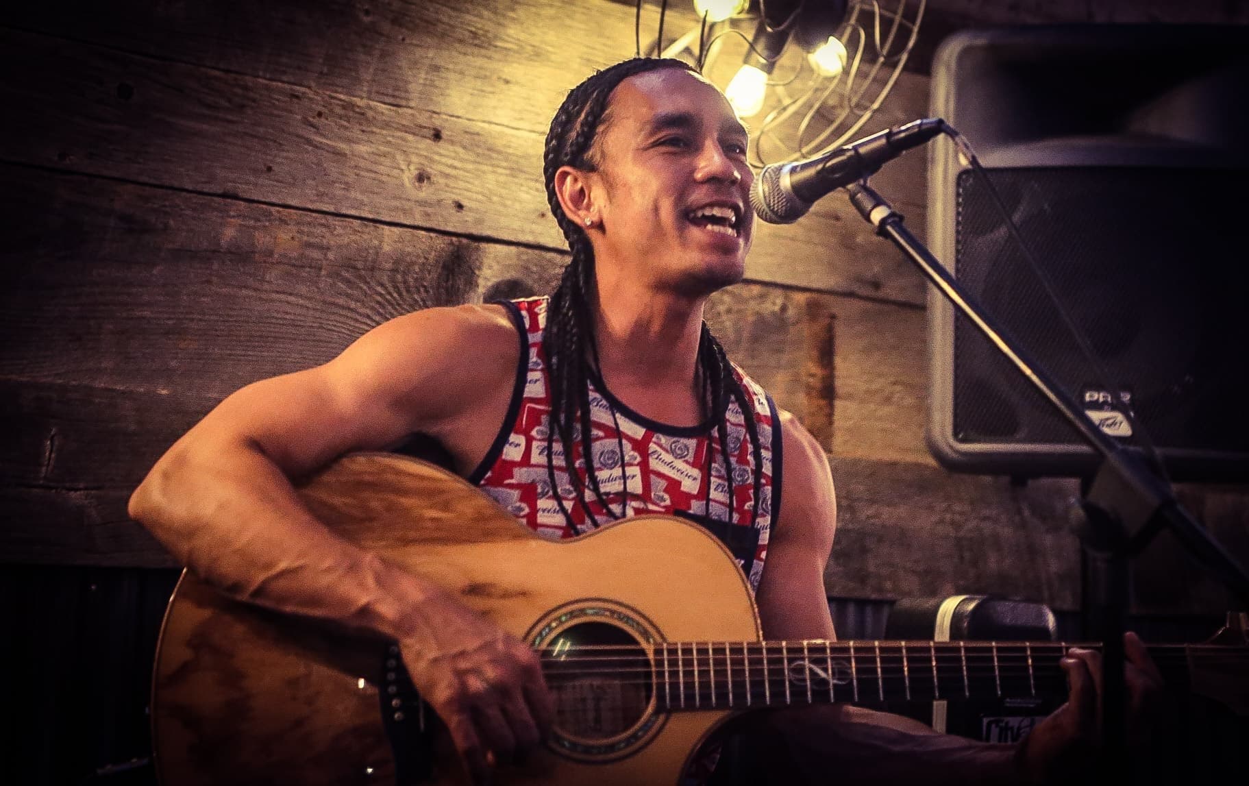 Kekoa singing with an acoustic guitar